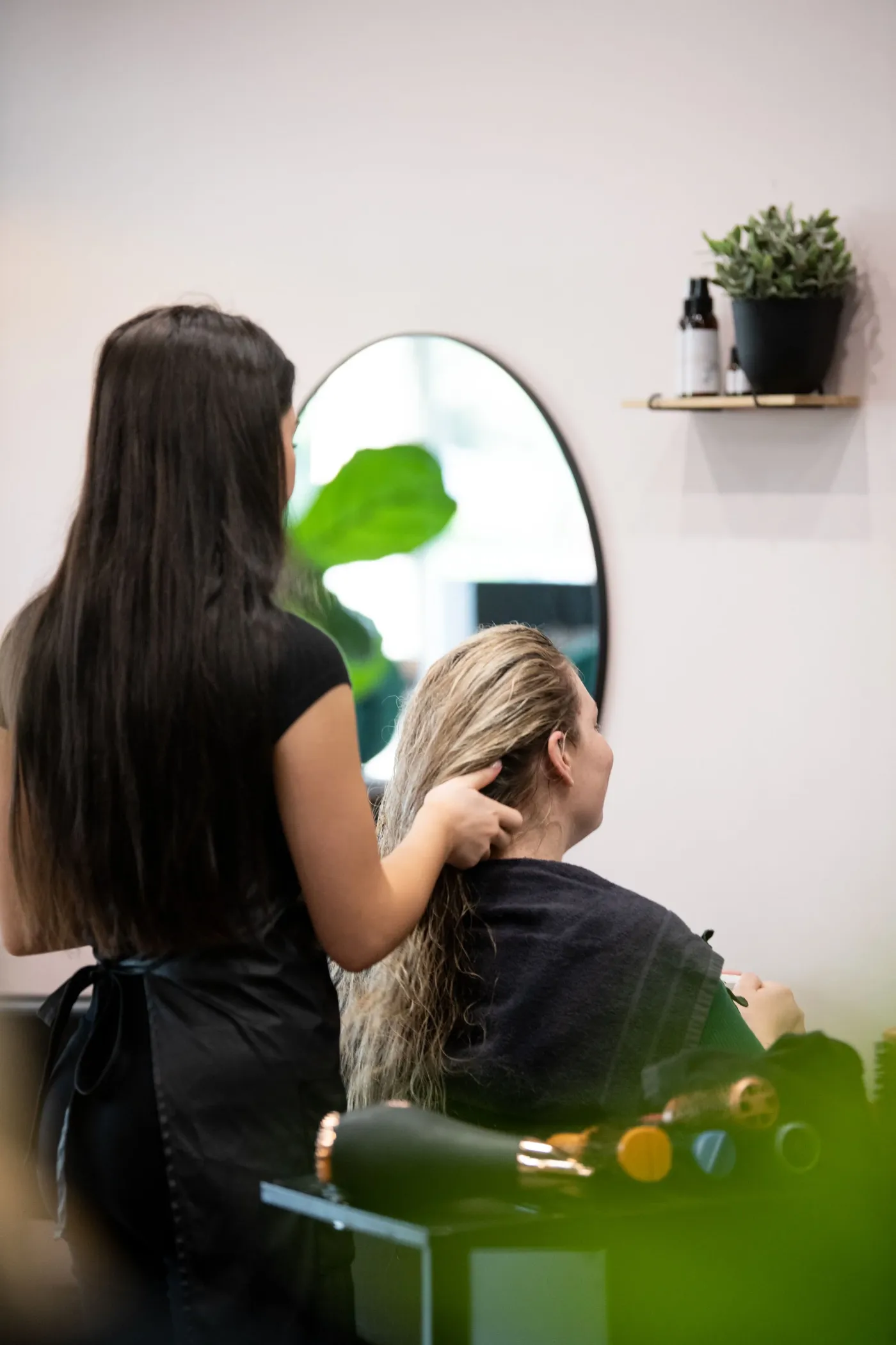 A stylist cutting long hair at Satori Hair Kingsville, a sustainable Melbourne salon