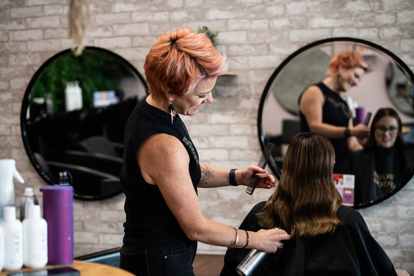 A Satori Hair stylist combing out a client's freshly cut hair at the Kingsville salon in Melbourne's west